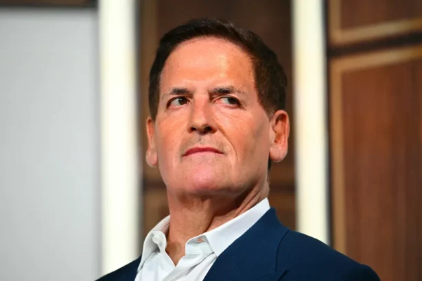Portrait of a middle-aged man in a navy suit and white shirt, looking to the left.