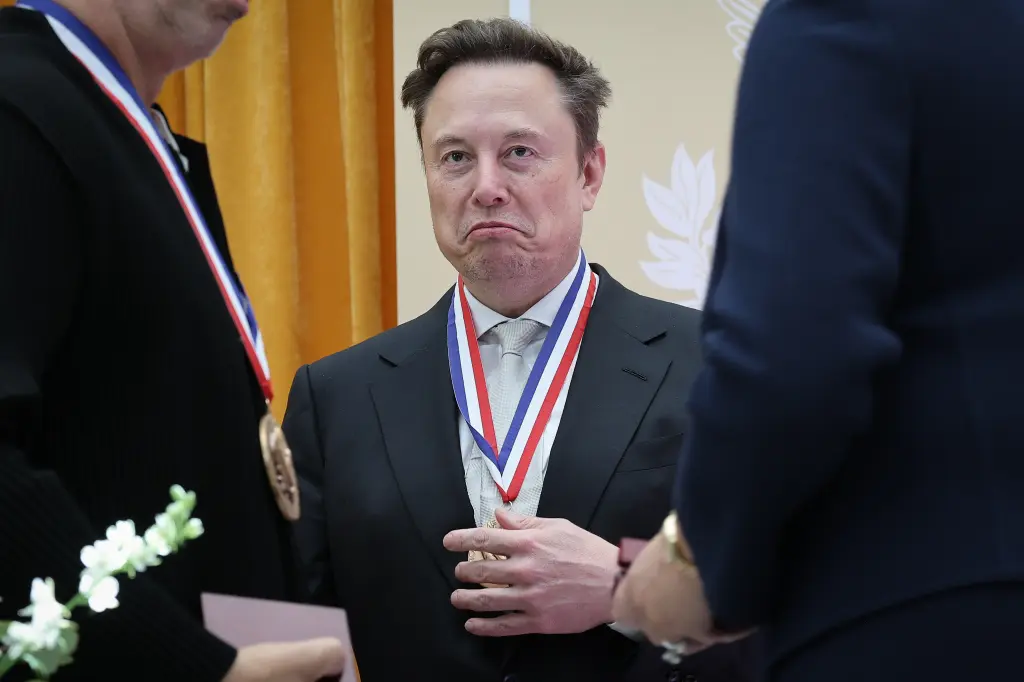 Elon Musk wearing a medal at an event